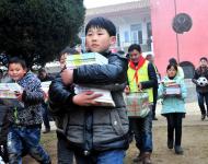 2016年1月8日下午,在駐馬店市汝南縣三門閘街道大新莊小學校院內(nèi)，駐馬店市陽光助學協(xié)會負責人及志愿者、大新莊學校師生、學生家長歡聚一堂，舉行了“陽光助學愛心圖書室”捐贈儀式。圖為學生和志愿者一起搬運新書