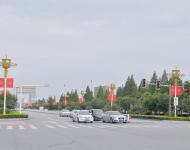 駐馬店市開源大道，道路兩旁清一色的紅旗在迎風(fēng)飄揚(yáng)。所有紅旗都是在燈桿的一側(cè)逆時(shí)針旋轉(zhuǎn)90°豎著懸掛，鮮艷的國(guó)旗整齊地朝向一側(cè)，非常壯觀。