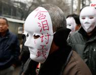 近幾年，由于經濟增速下行，中西部地區(qū)和中小城市成為當前討薪矛盾多發(fā)地區(qū)。一邊是國家和地方維護打工者權益的法律法規(guī)不斷出臺，另一邊則是“年年干活年年欠，年年討薪年年難”。不少打工者不得已只好采取行為藝術等手段以博取關注。圖為2015年2月2日，西安市尚德路陜西省水利廳的門前，七八位頭戴著白色面具者站在凜凜寒風中，面具上寫著：“含淚討工錢” “無顏見父母”等標語。據了解，這幾個人是70名農民工的代表，他們之前在武功縣干的工程被欠款156萬元。誰知，包工頭不但電話打不通，以前的家也搬了，根本找不到人，多次找到水