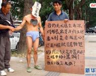 2011年11月22日，深圳福田區(qū)東園路上，河南籍農民工韓文德雇人頭戴“黑心老板”面具，只穿一條內褲走在街上，這么做是為了討要承包方欠下的21萬元工錢。他表示，自己和13名老鄉(xiāng)去年底參與深圳某大廈外墻翻新工程，今年8月完工后沒拿到應得的工資，希望這樣的方式能引起有關方面的重視。經記者調查發(fā)現，勞資雙方的合同沒有文字憑據，成了一筆死無對證的“糊涂賬”。新華社發(fā)