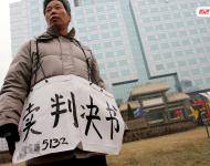 2006年1月24日，在京從事降水井工程的老陳掛著寫有“賣判決書”的紙口袋在北京站口附近來回走著。曾是名小工頭的老陳被欠工程款4萬元，為了給工人們開資不得已賣掉了打井機器。2002年法院宣判老陳勝訴，可四年后該判決仍得不到執(zhí)行，無奈之中老陳只好上演此幕。程寧/視覺中國