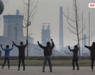 圖為耗資13億建成的邯鄲武安市體育館外，本地的不少中年婦女，每天會在固定時間來到這里：她們背對體育館，面向文安鋼鐵廠，跳起了廣場舞。邯鄲武安市區(qū)有十幾個鋼鐵廠、電廠、焦化廠包圍，不管刮什么風，城區(qū)污染都很嚴重。視覺中國
